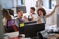 Colleagues, male and female, sharing a good news at work. woman throwing papers from happiness, man raised his fists. good news at Royalty Free Stock Photo