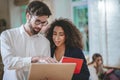 Guy with laptop showing screen to girl with notebook Royalty Free Stock Photo