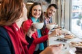 Colleagues smiling while eating delicious cakes during break in a coffee shop