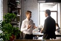 Colleagues standing having casual conversation in office