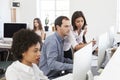 Colleagues talking at work in a busy open plan office, close up Royalty Free Stock Photo