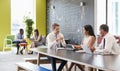 Colleagues talking at work in an informal meeting area