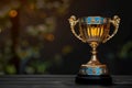 A collectable gold trophy is elegantly displayed on a wooden table in a still life photography setting. The metal gleams