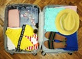 Collected suitcase for travel. Suitcase in open view closeup with things to rest on a wooden background