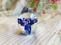 Heavy Lead Crystal Blue Pink and Clear Paperweight on Floral Background