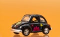 Collectible toy model car Volkswagen Beetle decorated in Hippie lifestyle. Side view