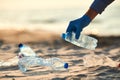 Collecting plastic bottles on sea beach. Cleaning environmental pollution