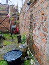 Collecting rainwater from a gutter into buckets and basins outdoors. Royalty Free Stock Photo