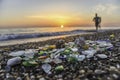 Collecting shells on beach at sunset, hobby of collecting seashells, sea glass, shells and pebbles in sandy beach and waves, in ba Royalty Free Stock Photo
