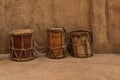 Collection of ancient vintage wooden drums near clay walls in heritage village .Percussion oriental musical instruments