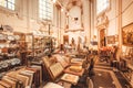 Collection of antique books, porcelain, paintings, retro furniture in old shop inside church structure Royalty Free Stock Photo