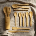 A collection of bamboo cutlery is displayed on a textured beige fabric. The set Royalty Free Stock Photo