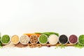 collection of beans and legumes in wooden spoons on white background