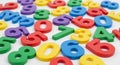 Assortment of Colorful Plastic Numbers Scattered on a White Surface digits learning Royalty Free Stock Photo