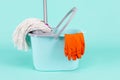 Collection of Bucket, Mop and Cleaning Supplies On Turquoise Background Indoors Royalty Free Stock Photo