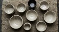 A collection of ceramic bowls displayed on a rough, textured stone surface. The bowls Royalty Free Stock Photo