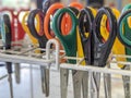 A collection of classroom scissors upside down in a rack