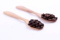 A collection of coffee beans on a wooden spoon