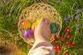 Collection of colored eggs by children.Easter Egg Hunt. Childs hand puts colorful eggs in a wicker basket in blue Royalty Free Stock Photo