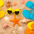 A collection of colorful flip flops and sunglasses are on a beach.  Beach accessories Royalty Free Stock Photo