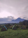 A collection of colorful inns with unique architecture in a natural resort with a mountain backdrop in Indonesia