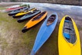 Collection of colorful kayaks on riverside at summer day