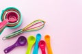 Collection of colorful measuring cups, measuring spoons and whisk