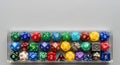 Collection of Colorful Multi-sided Dice in Clear Plastic Container on White Background Royalty Free Stock Photo