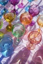 Collection of colorful wine glasses casting vibrant shadows Royalty Free Stock Photo
