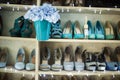 Collection of colourful shoes on shelves in interior.