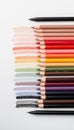 A collection of cosmetic makeup pencils arranged in a gradient. The colors range from light pinks to deep reds, white background. Royalty Free Stock Photo