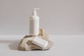 Collection of cosmetic products on beige background. White plastic pump bottle for shampoo, lotion mockup on stone