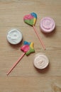 A collection of different jars of body lotion displayed with a star shape lollipop and a heart shape lollipop