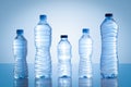 Collection of different plastic water bottles isolated on blue background Royalty Free Stock Photo