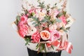 Collection of different varieties of garden roses, carnations and eucalyptus. Girl`s hands holding gentle colors flowers