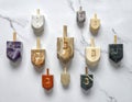 A collection of diverse dreidels crafted from various materials displayed neatly on a luxurious Royalty Free Stock Photo