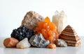Collection of diverse mineral rocks and crystal formations arranged on a table. Includes orange calcite, quartz points, and Royalty Free Stock Photo