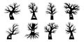 Collection of drawn silhouettes of trees without leaves and foliage. Halloween haunted faces on the tree. Scary smiles Royalty Free Stock Photo