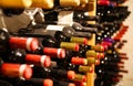 Collection of dusty red wine bottles in a shelf in a row