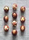 A collection of Easter eggs stained with onion husks with imprints of fresh leaves, on a fabric background. Creative design.