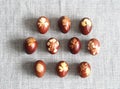 A collection of Easter eggs stained with onion husks with imprints of fresh leaves, on a fabric background. Creative design.