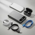 Smartphone, wireless earbuds in a case, a portable power bank, and three Royalty Free Stock Photo