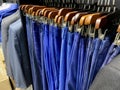 A collection of elegant men\'s trousers and casual pants hanging in a row in a men\'s fashion store Royalty Free Stock Photo