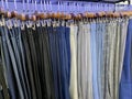 A collection of elegant men\'s trousers and casual pants hanging in a row in a men\'s fashion store Royalty Free Stock Photo