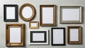 A collection of empty picture frames on a textured white wall. The frames vary in size, shape, and Royalty Free Stock Photo