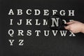 Collection of English letters alphabetical order from A to Z. Hand holding magnifying glass over letters Royalty Free Stock Photo