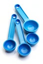 Five Blue Plastic Measuring Spoons and Bowls on a White Background measuring cups kitchenware Royalty Free Stock Photo