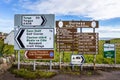 Collection of four directional signs set up on the side of the road in Durness, United Kingdom