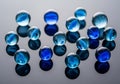 A collection of glass marbles rests on a reflective surface. The marbles vary in shades of blue, Royalty Free Stock Photo