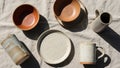 Collection of handmade ceramic tableware is displayed on a textured beige Royalty Free Stock Photo